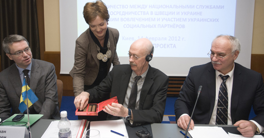 Projektledare Irina Norström smörjer relationerna med chokladhjärtan när chefsjurist Kurt Eriksson från Medlingsinstitutet och Oleksander Okis, chef för ukrainska medlingsfunktionen, samlats med övriga projektdeltagare till kickoff I Kiev på Alla hjärtans dag i februari.