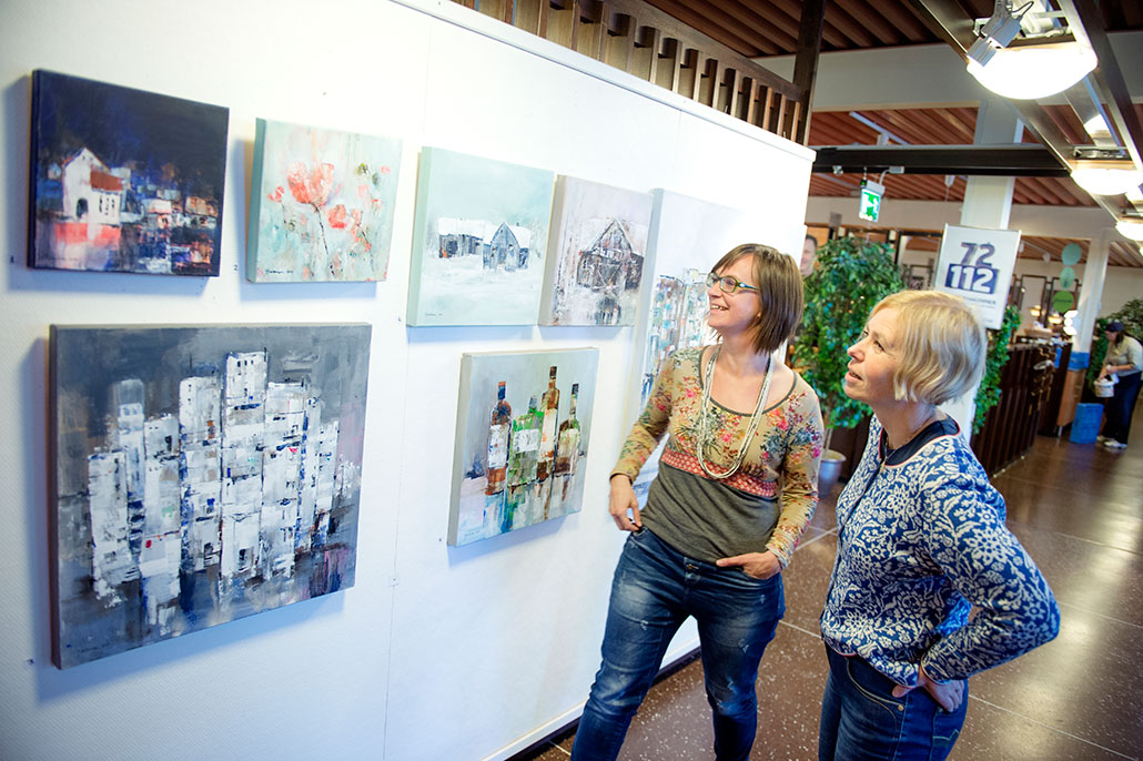 – Hon är jäkligt duktig. Speciellt när vi vet hur svårt akvarell är, säger Anna Östlund, till höger, och Karin Hoppe Storck håller med, när de visar Morakonstnären Annette Backmans verk i personalmatsalen Blå lådan. Foto: Ulf Palm