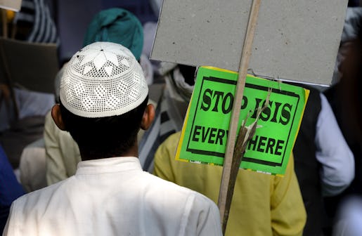 An Indian Muslim man holds a banner and listens to a speaker during a protest against ISIS, an Islamic State group, and Friday's Paris attacks, in New Delhi, India, Wednesday, Nov. 18, 2015. Multiple attacks across Paris on Friday night have left more than one hundred dead and many more injured. (AP Photo/Manish Swarup)