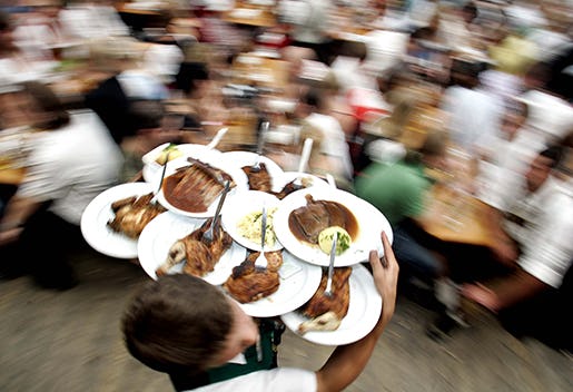 A waiter serves food during the last day of the 173rd Oktoberfest beer festival in Munich, southern Germany, on Tuesday, Oct. 3, 2006. (AP Photo/Christof Stache)