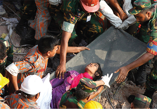 En överlevare dras fram ur ruinerna efter den kollapsade fabriksbyggnaden Rana Plaza i Dhaka. I Modeslavar möter författarna flera som överlevde katastrofen, där 1 100 människor miste livet. Foto: A. M. Ahad