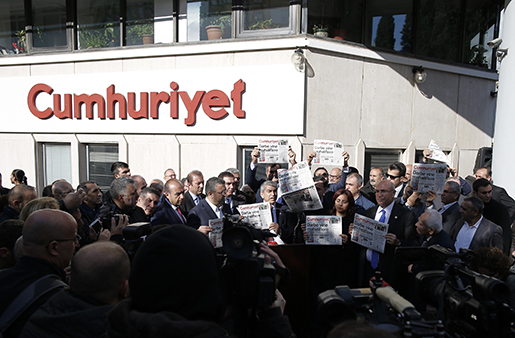 Journalists and lawmakers hold copies of the latest Cumhuriyet newspaper outside its Istanbul headquarters after police detained chief editor Murat Sabuncu and two columnists of Turkey's opposition Cumhuriyet and had warrants to detain 10 other senior staff members, in Istanbul, Monday, Oct. 31, 2016, the state-run-Anadolu Agency reported, amid growing fears over Turkey's widening crackdown on dissenting voices. Cumhuriyet's headline reads: "The coup against opposition again." (AP Photo/Emrah Gurel)