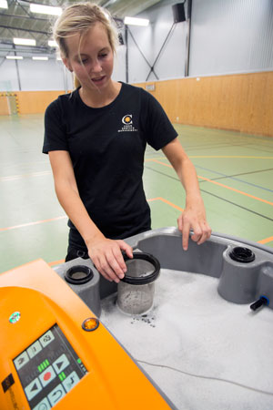 Städaren och robotoperatören Elin Antonsson visar vattentanken och ett de tre reningsfiltren.