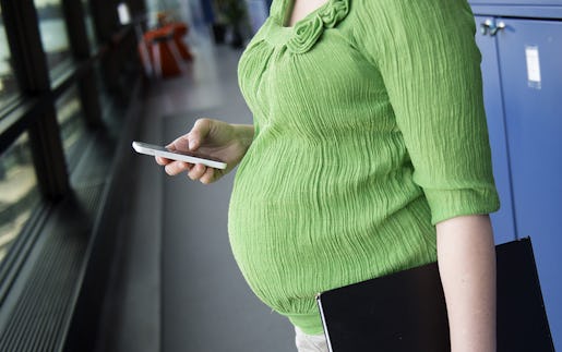 STOCKHOLM 20150422 Gravid kvinna p jobbet med mobiltelefon och p‰rm Foto: Jessica Gow / TT / Kod 10170