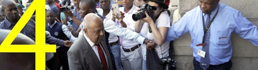 Pravin Gordhan, former South Africa's finance minister, center, walks into the National Treasury building in Pretoria, South Africa, Friday, March 31, 2017. South Africa faced political and financial turmoil on Friday after President Jacob Zuma fired the finance minister in a Cabinet reshuffle, intensifying a rift in the party that took power after the 1994 end of white minority rule as well as concerns about corruption at top levels of government. (AP Photo/Themba Hadebe)
