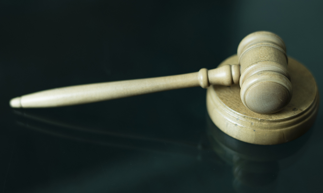 En träklubba som ligger på en mörk yta.