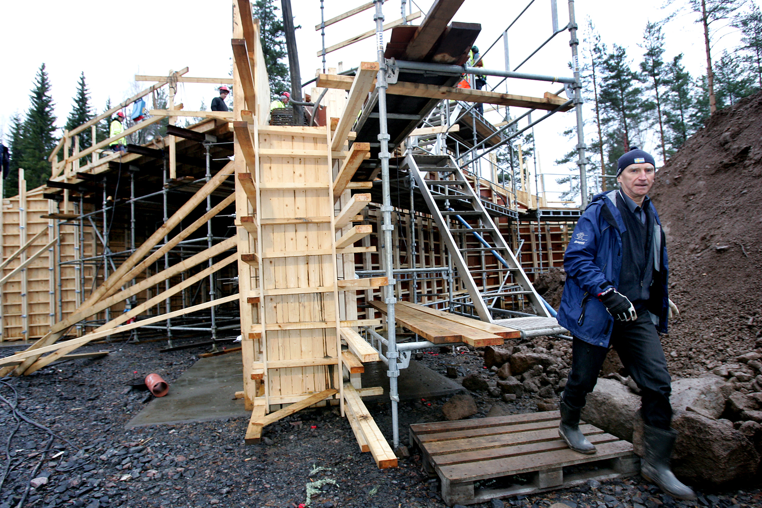 En person som går invid en byggställning.