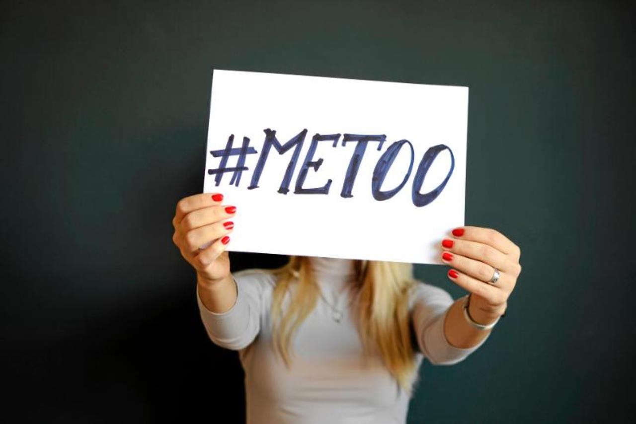 En person håller upp en skylt som det står Metoo på.