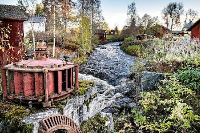 En röd turbin invid en fors