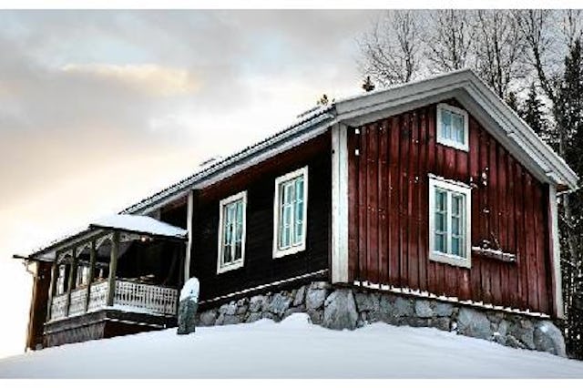 Ett rött trähus omgivet av snö