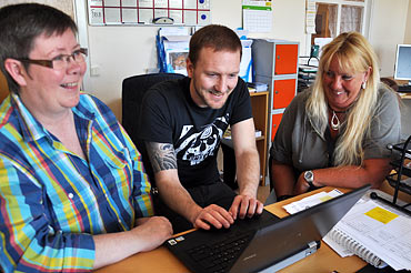 Eva, Andreas och Maria kollar Facebooksidan för sektion 14.