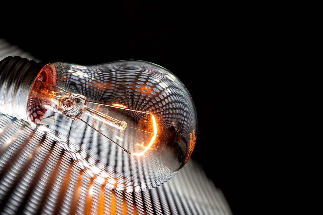 En tänd glödlampa ligger på ett metallgaller