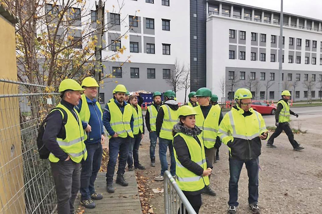 En samling personer i reflexvästar och gula hjälmar.