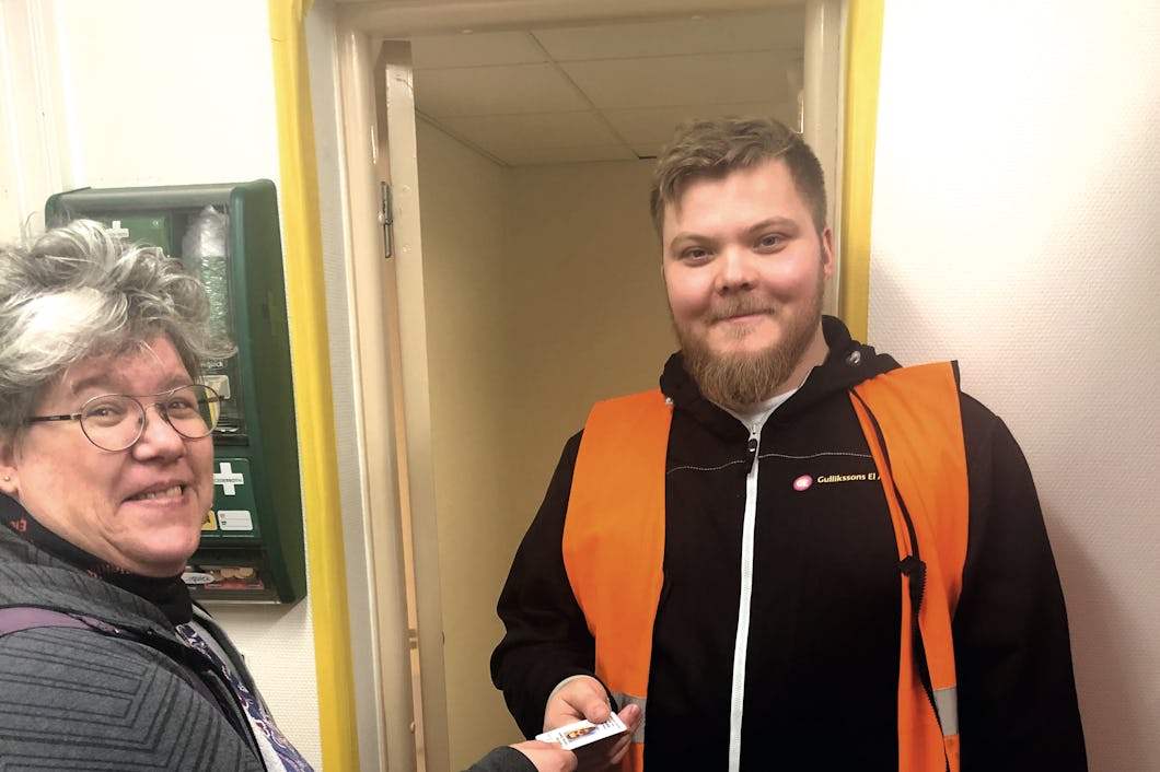 Ninni Blom överräcker ett papper till en person i orange väst