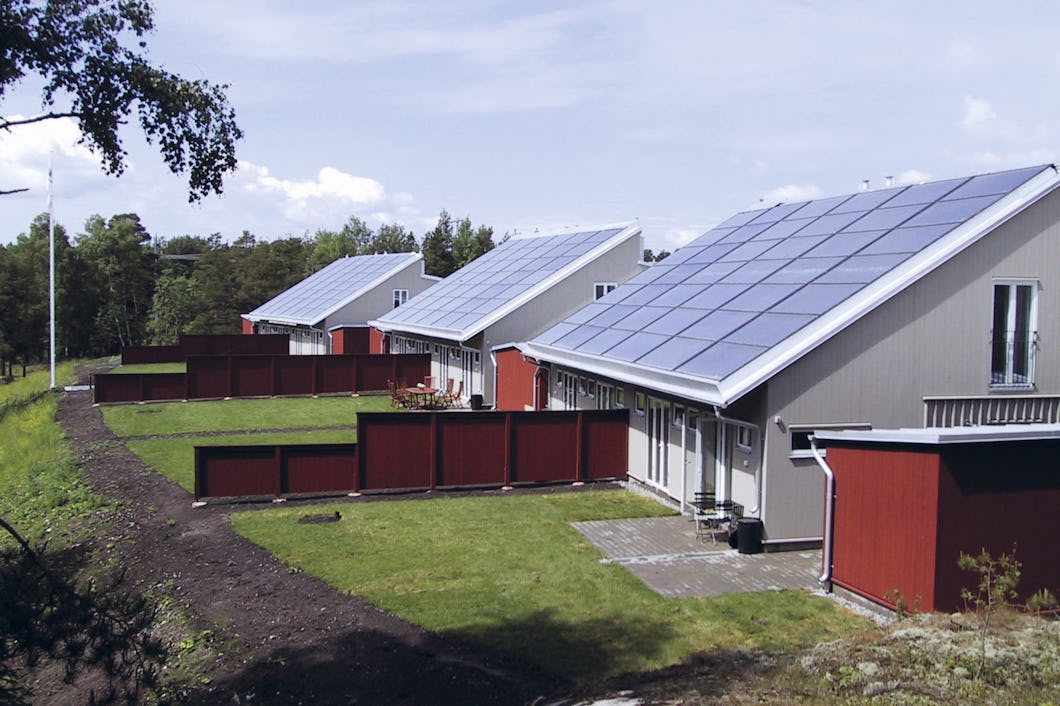En rad hus med solpaneler på taken
