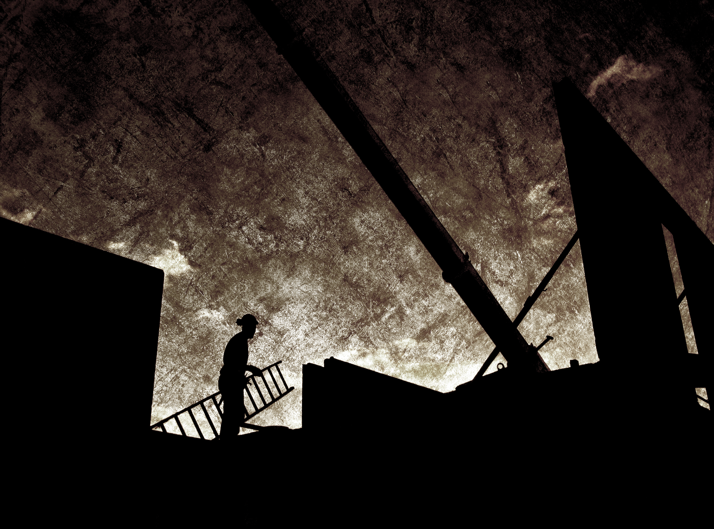 Silhuetten av en person hållandes en stege på en arbetsplats