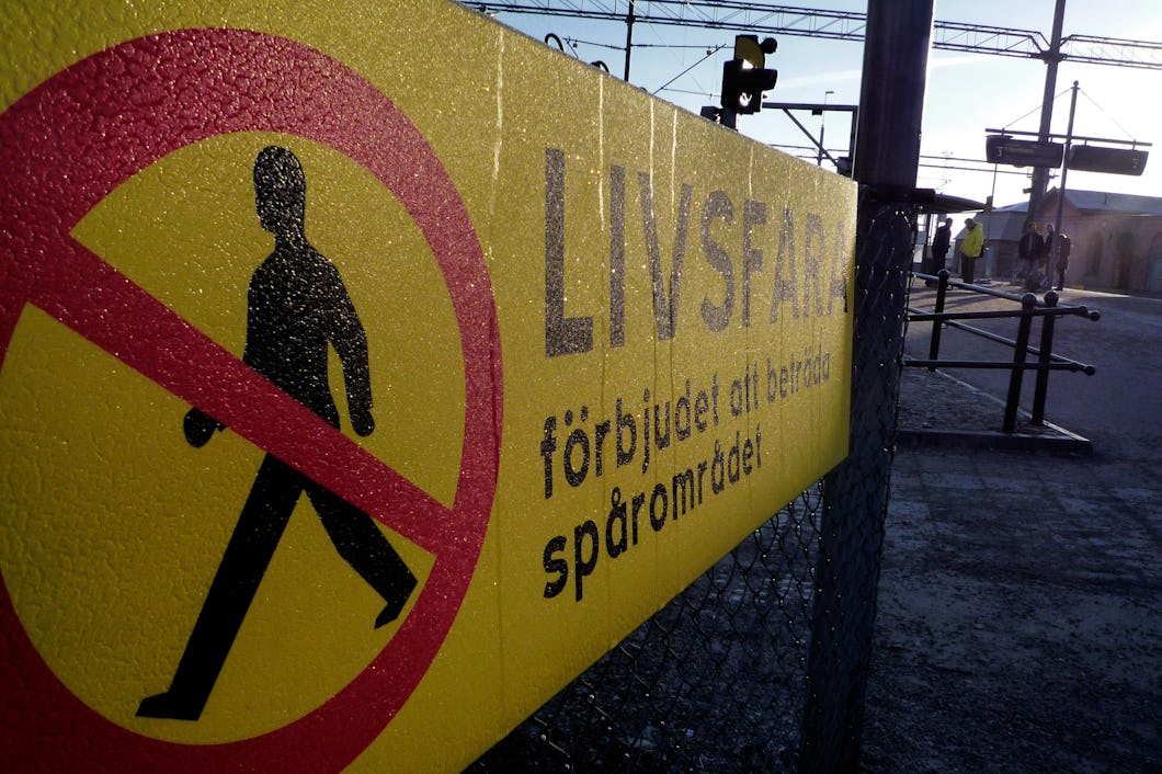 En varningsskylt med en överstruken fotgängare, och texten "Förbjudet att beträda spårområdet"