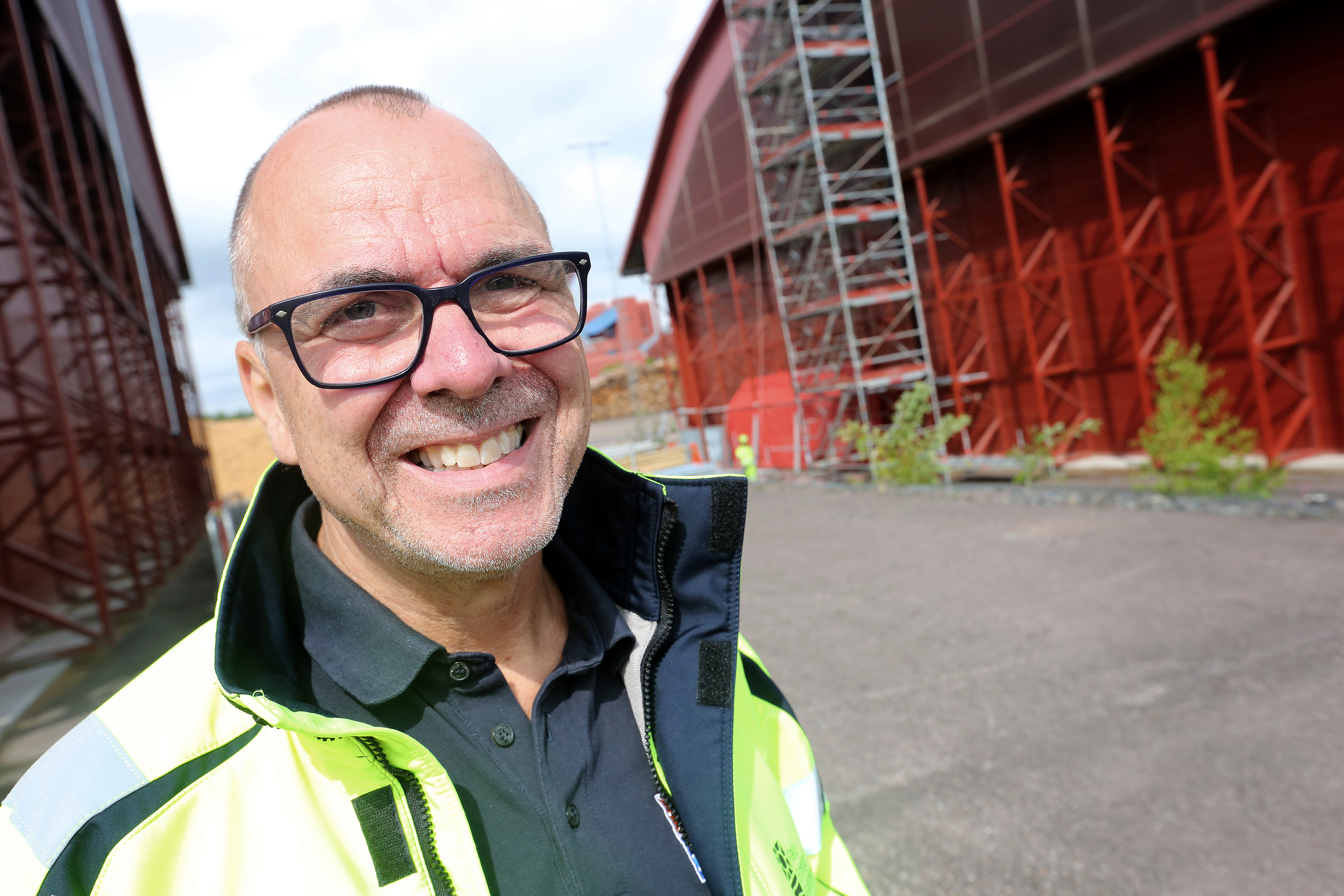 Per Magnusson framför en röd byggnad