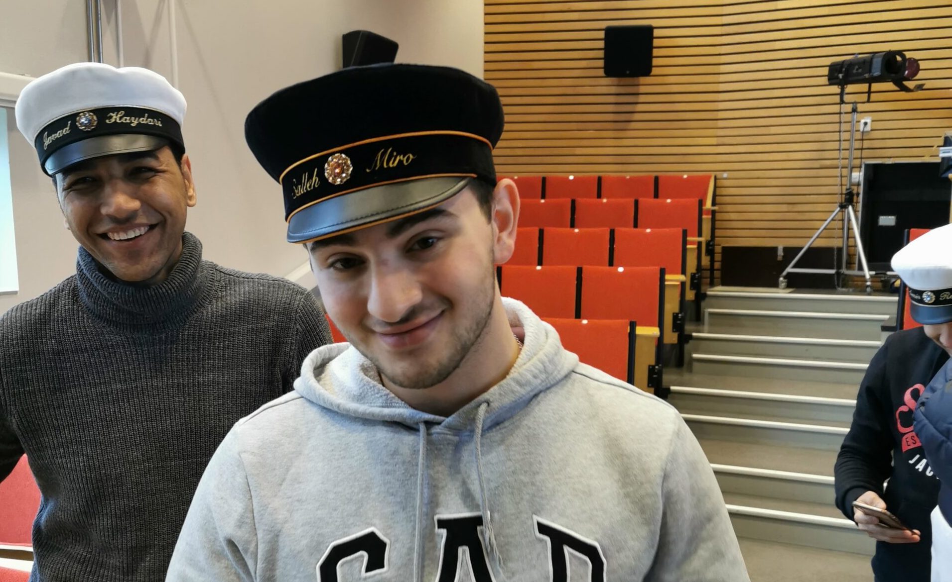 Salleh Miro och hans klasskompisar provar studentmössor