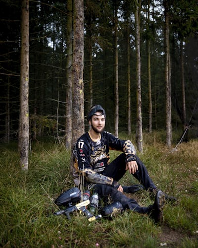 Alex Larsson med sin paintball-utrustning i skogen.