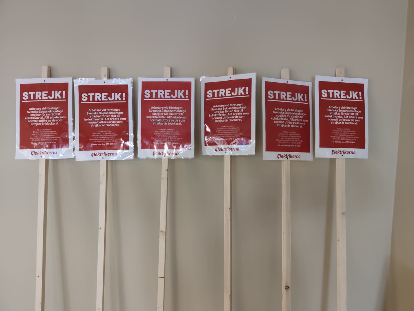 En samling strejkskyltar står lutade mot en vägg