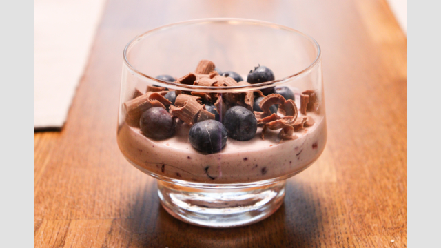 En blåbärsefterrätt i en skå med fot.