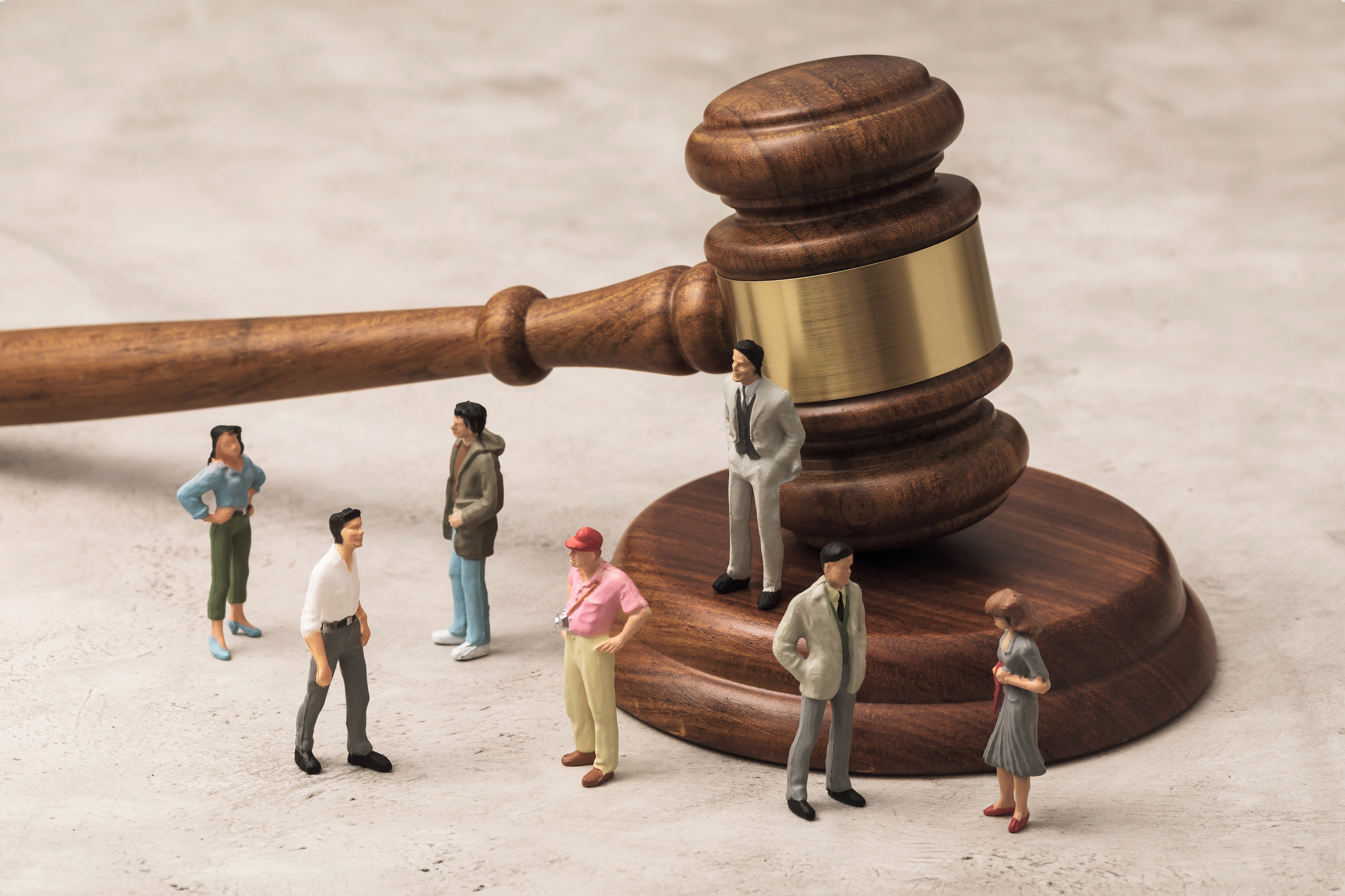 En samling leksaksmänniskor står runt en domarklubba