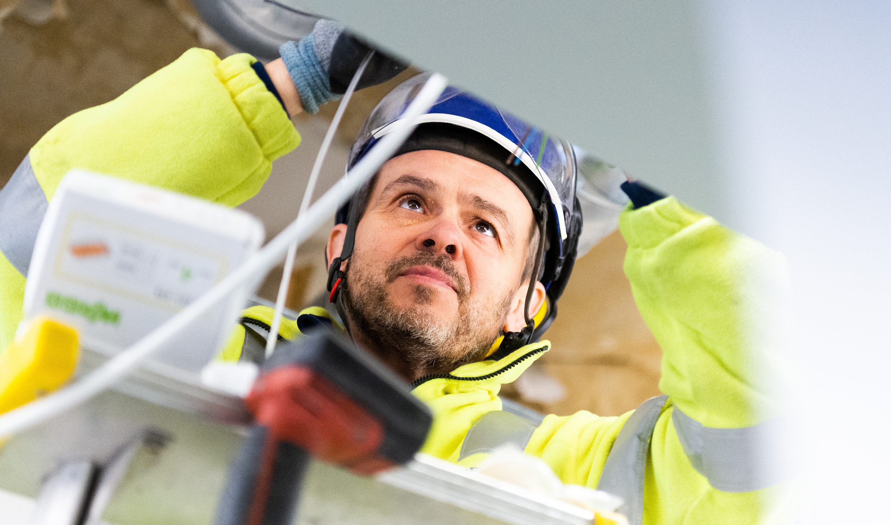 Viktor Alexandersson arbetar med sladdar i ett tak.