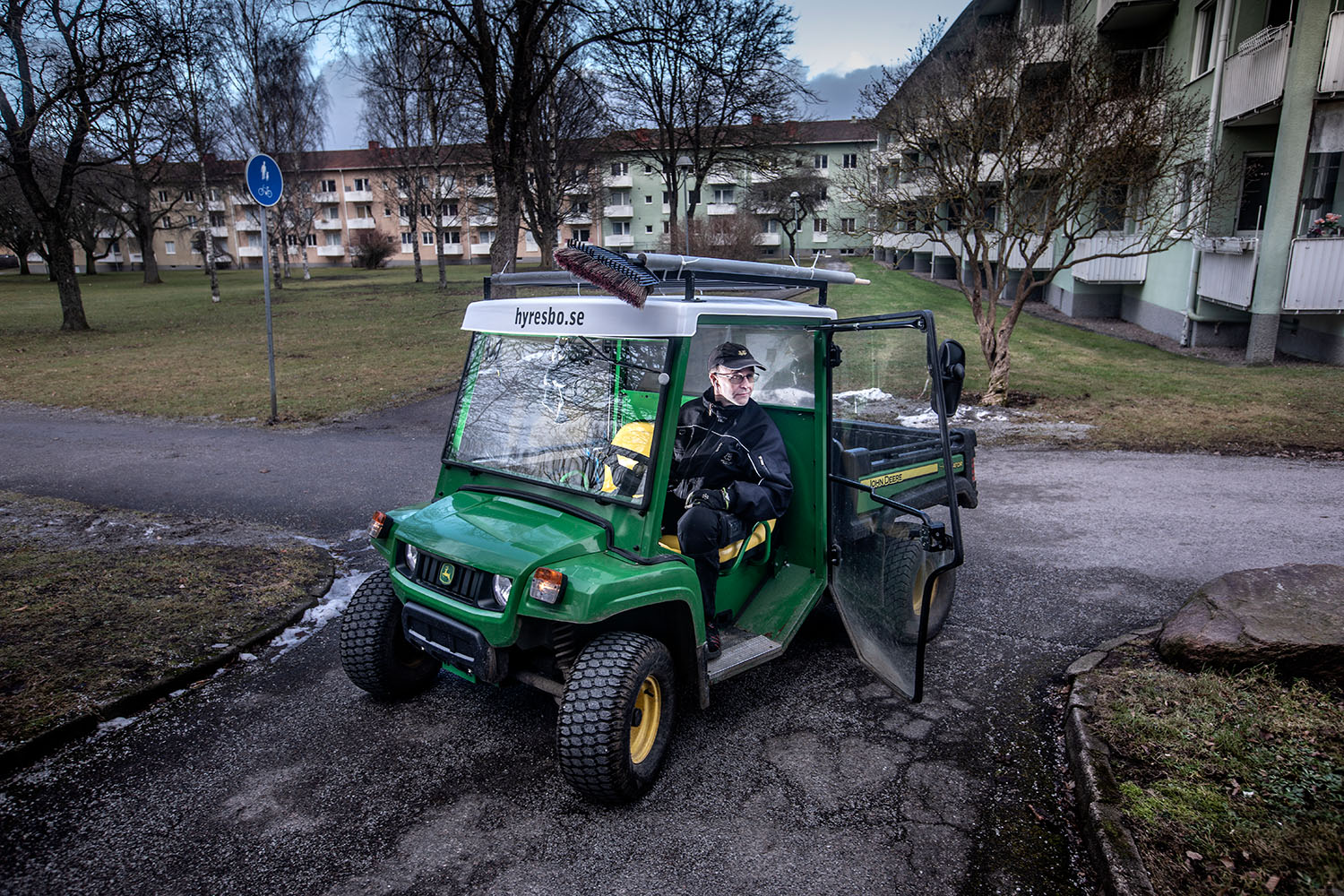 En fastighetsskötare i en grön elbil.
