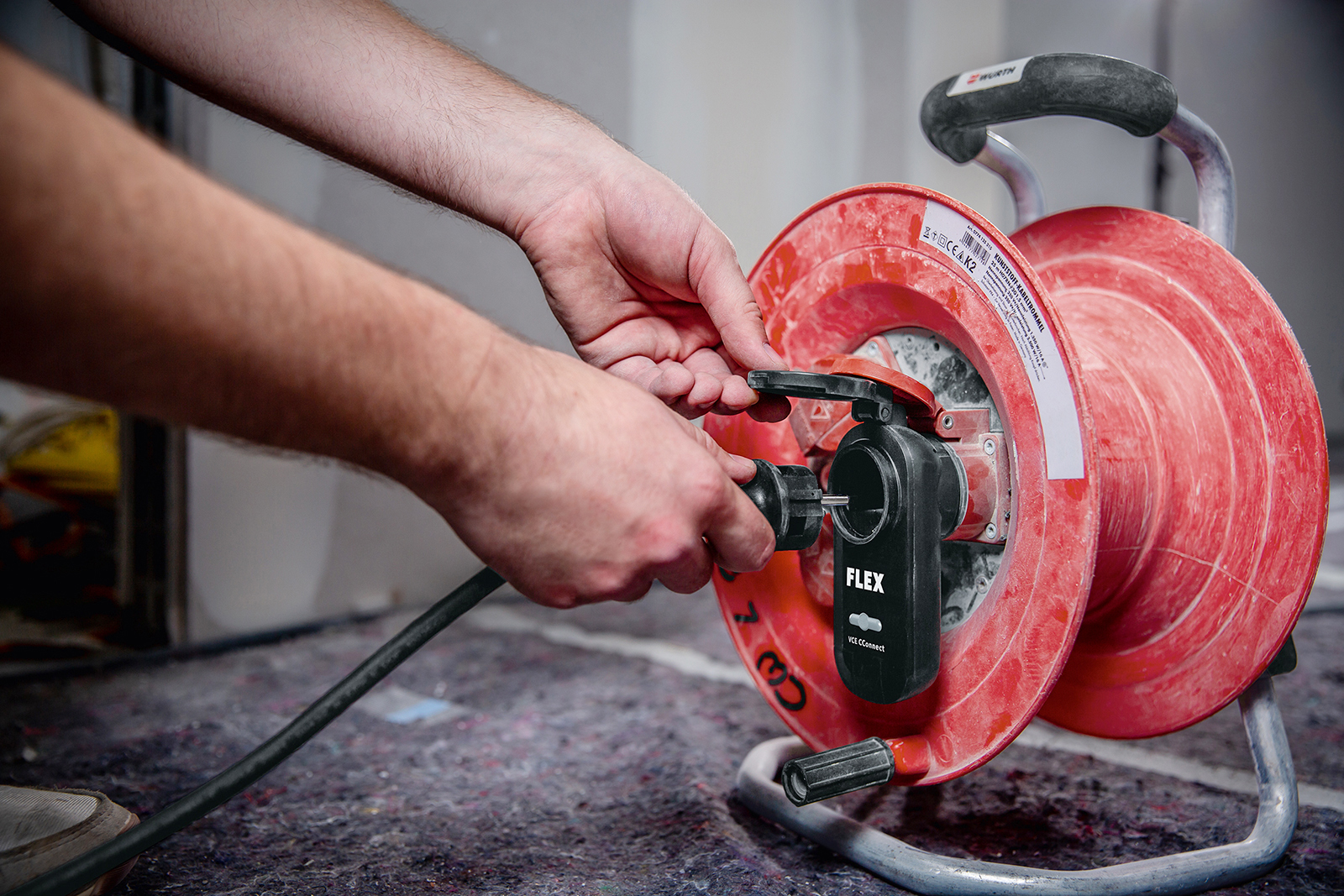 En person sätter in en sladd i ett eluttag.