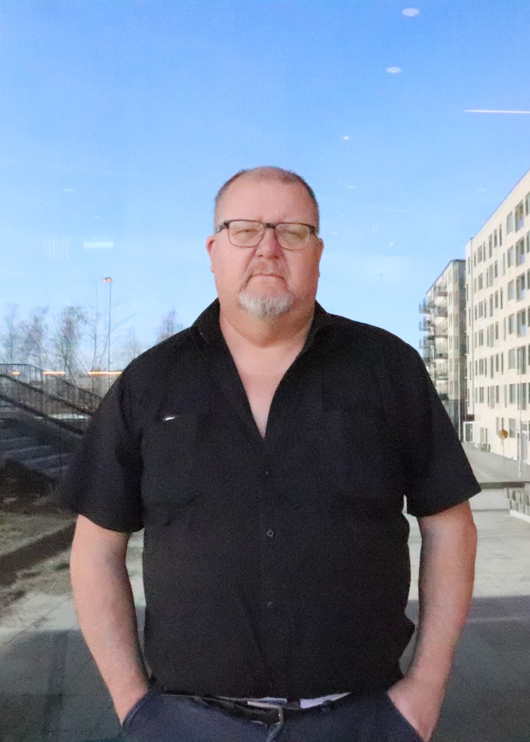 Håkan Johansson framför ett lägenhetshus