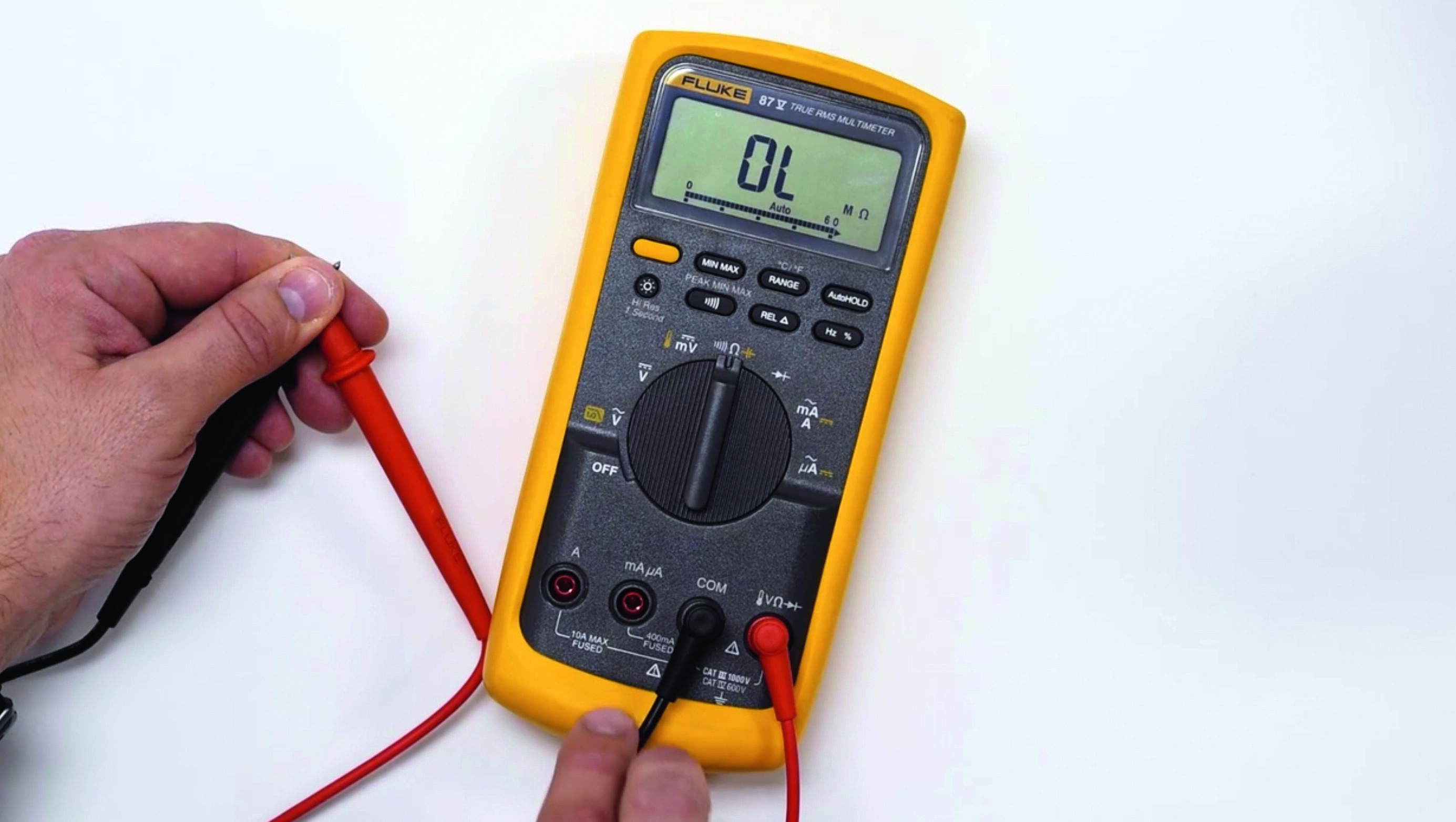 En person håller i en multimeter.