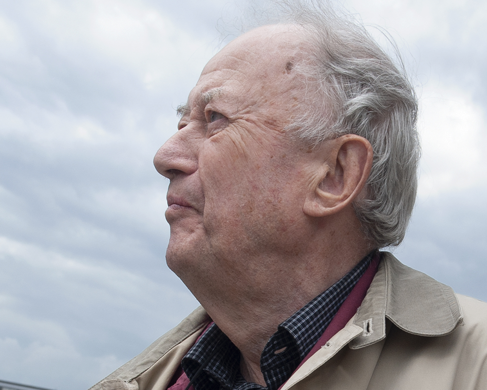 En äldre gråhårig man i profil.