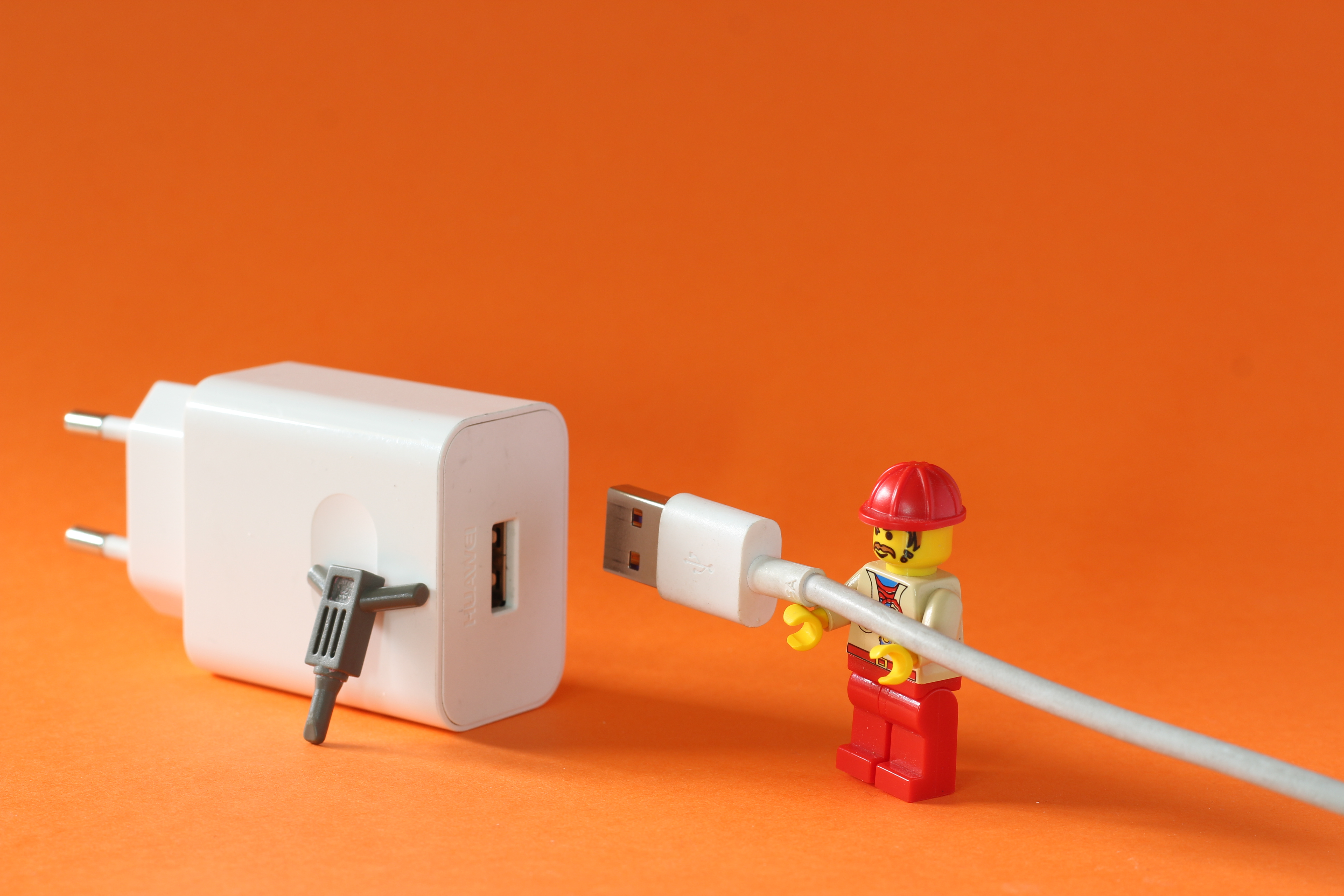 En legofigur kopplar in en USB-sladd i ett uttag.