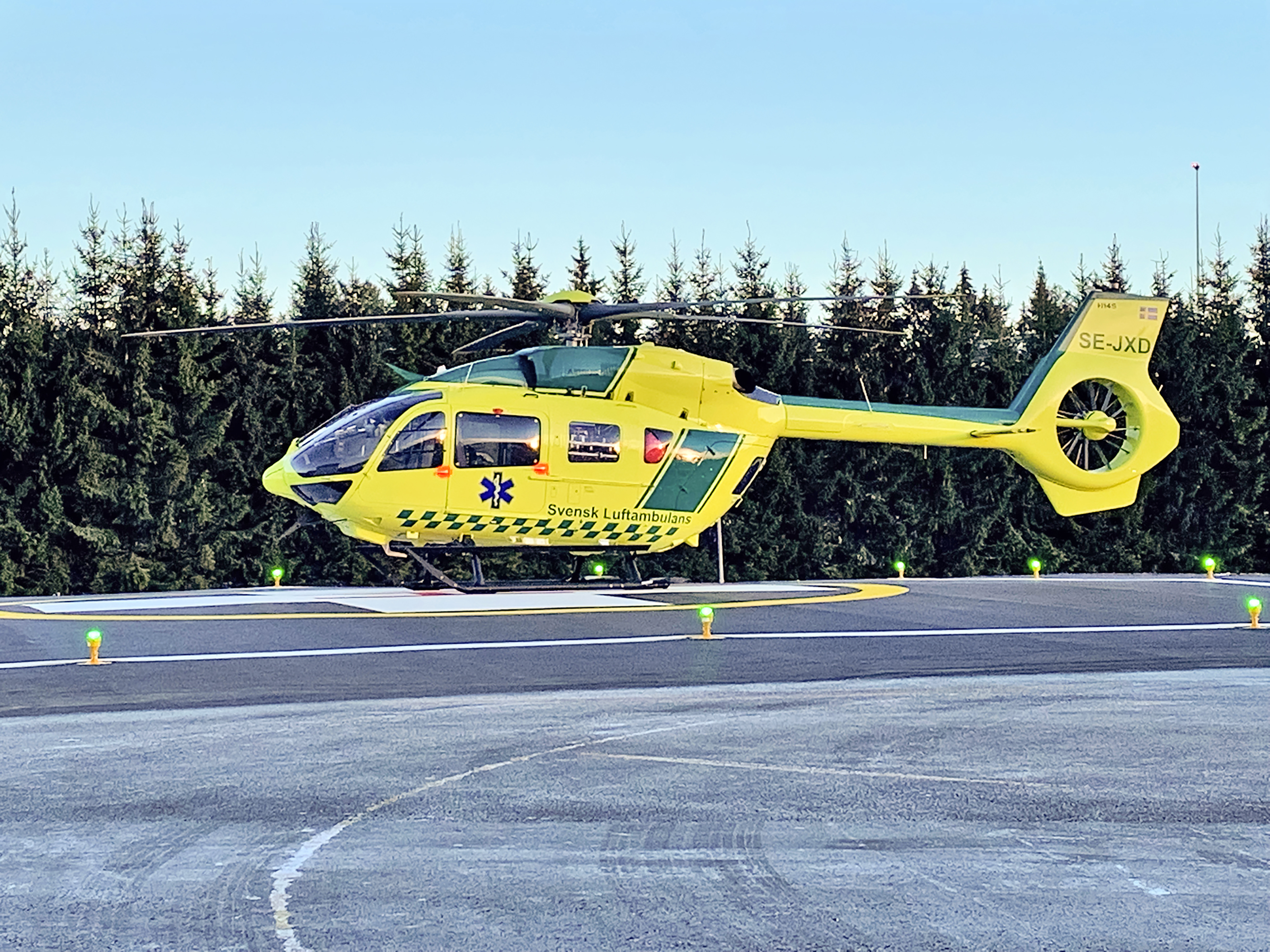 En helikopter svävande ovanför en landningsplatta.