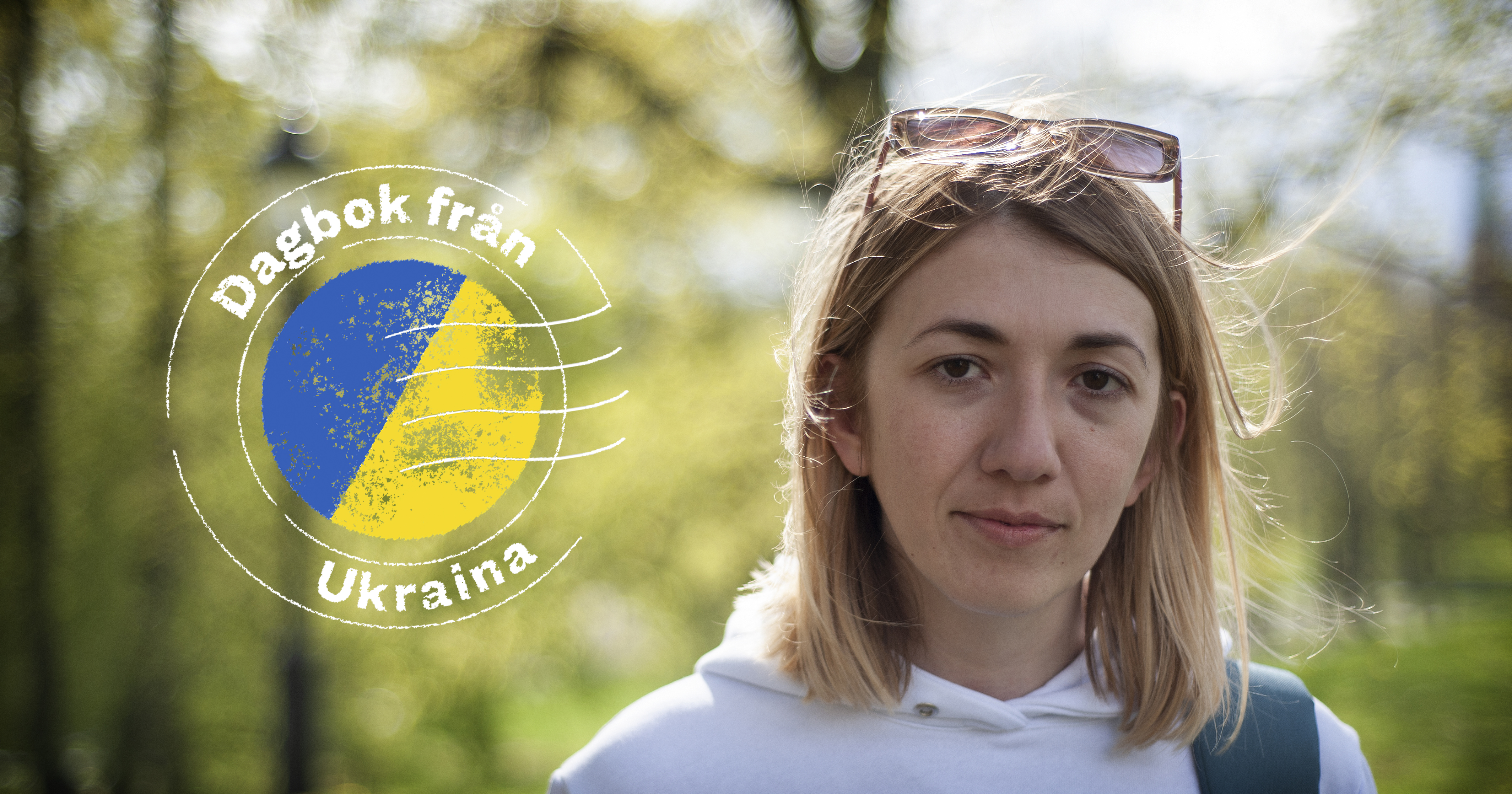 En blond kvinna, fotograferad i närbild i en park, hon tittar mot kameran. Till vänster i bilden finns en grafisk logotyp med texten "Dagbok från Ukraina".