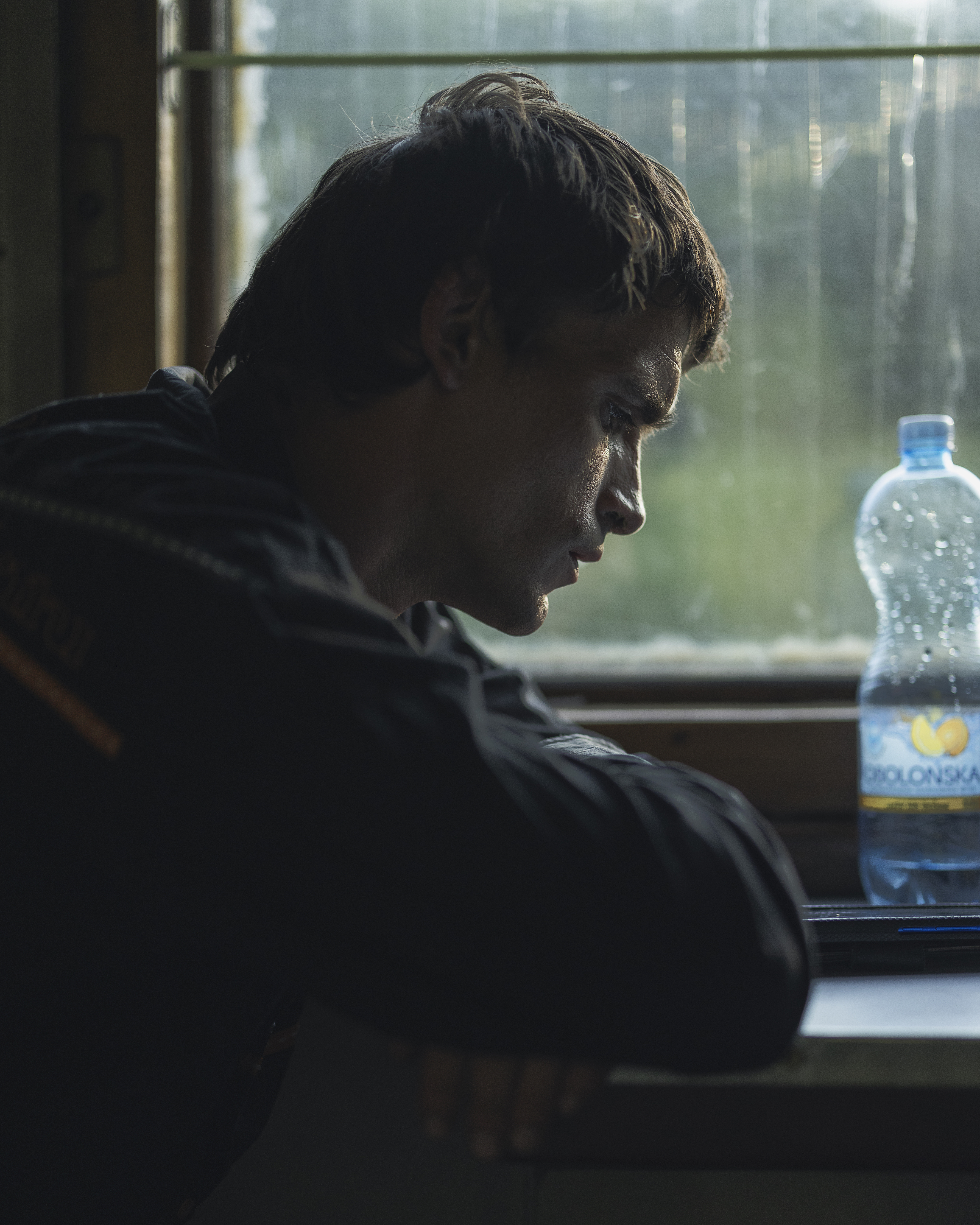En mörkhårig man i 30-årsåldern i profil framför en tågruta.