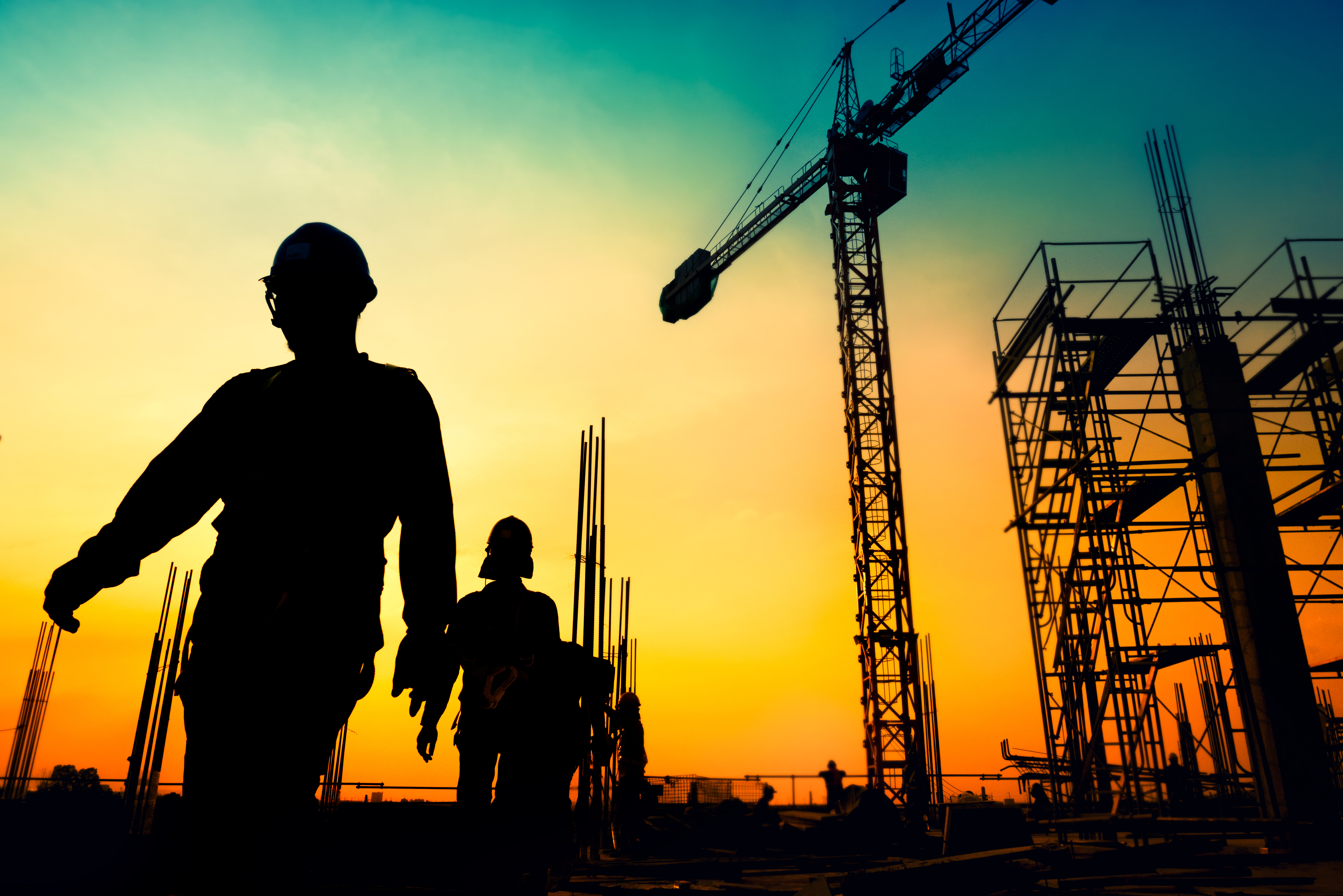 Silhuetterna av arbetare på ett bygge
