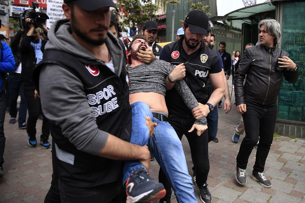 Turkisk polis bär bort en skrikande man från en demonstration.