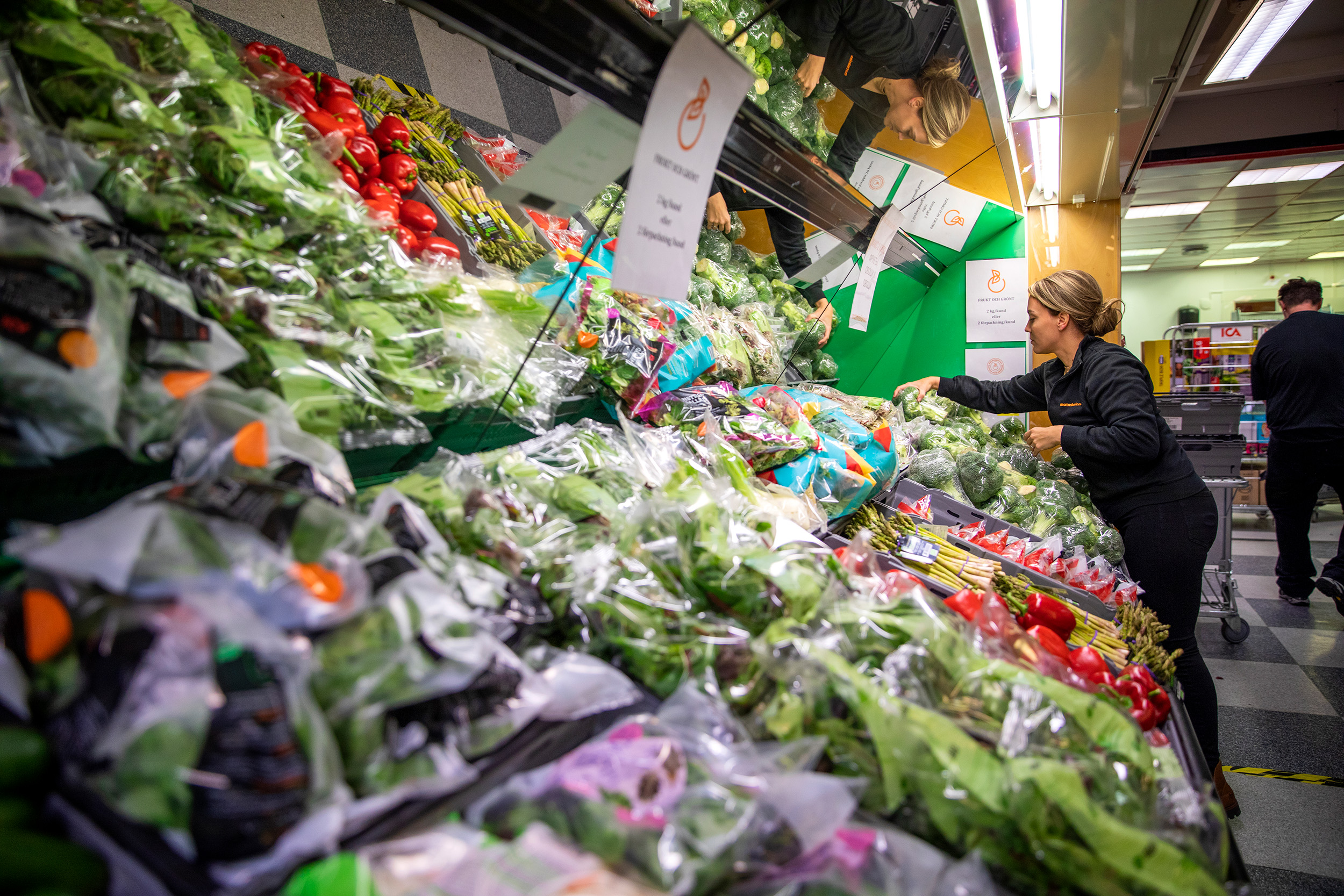 Alexandra Matrai sorterar grönsaker i butikens grönsaksdisk.