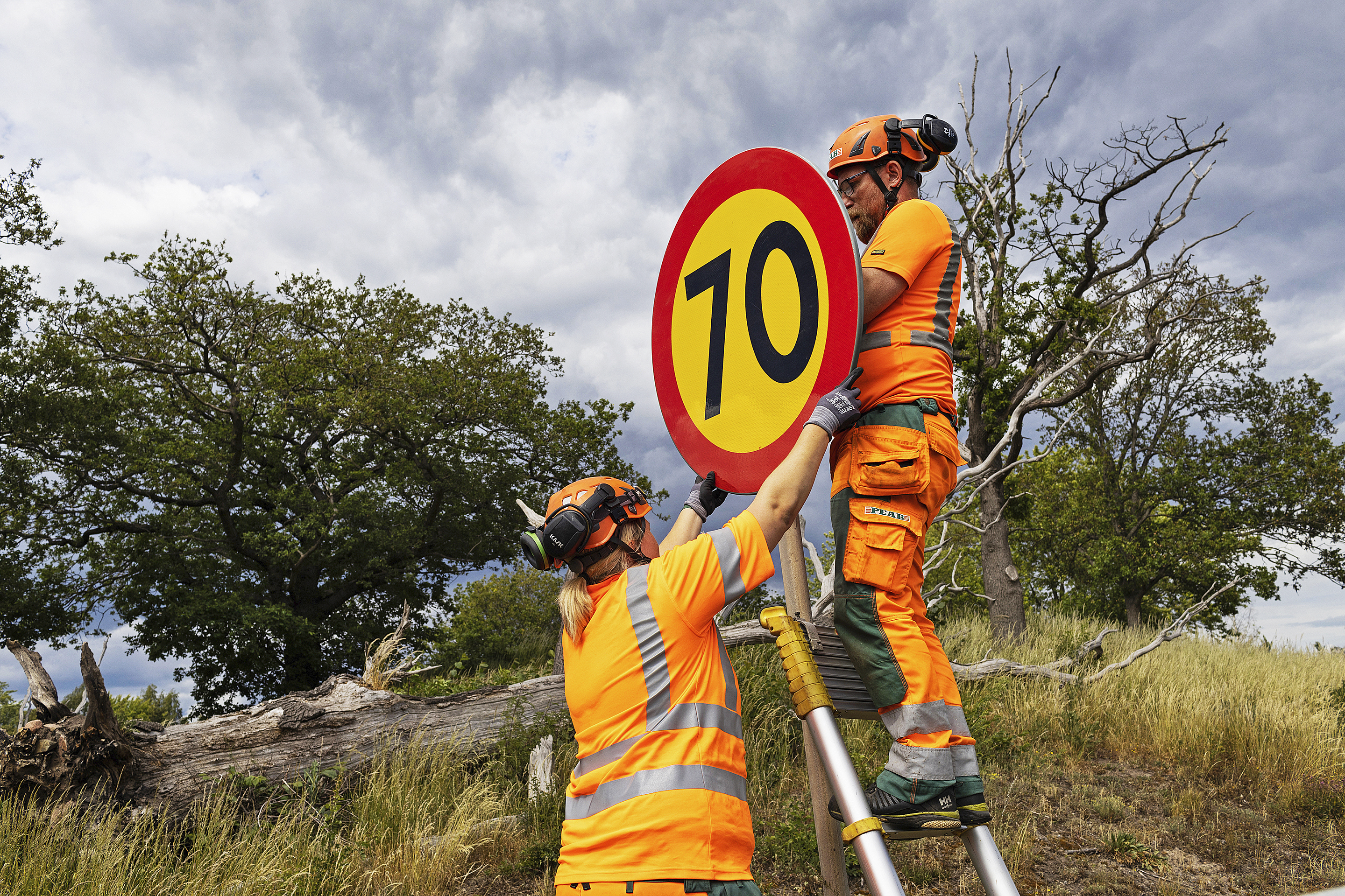 vägarbetare sätter upp skylt