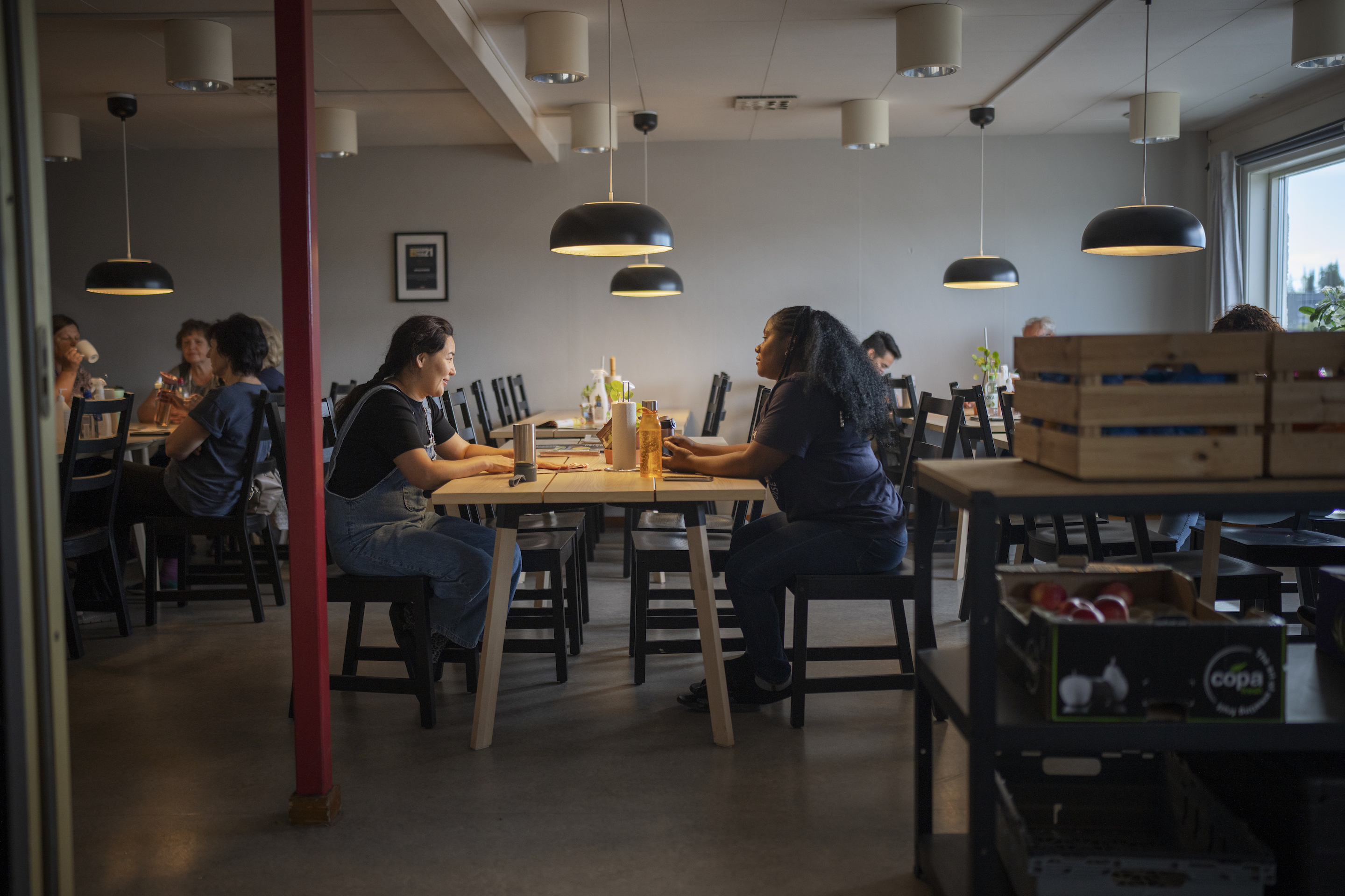 Två kvinnor fikar i en matsal.