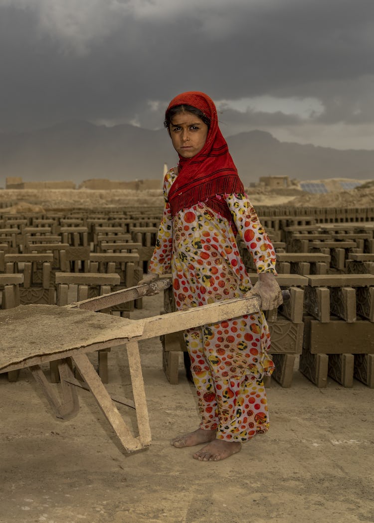En 9-årig flicka i en teglefabrik i Afghanistan, där barnarbete ökar.
