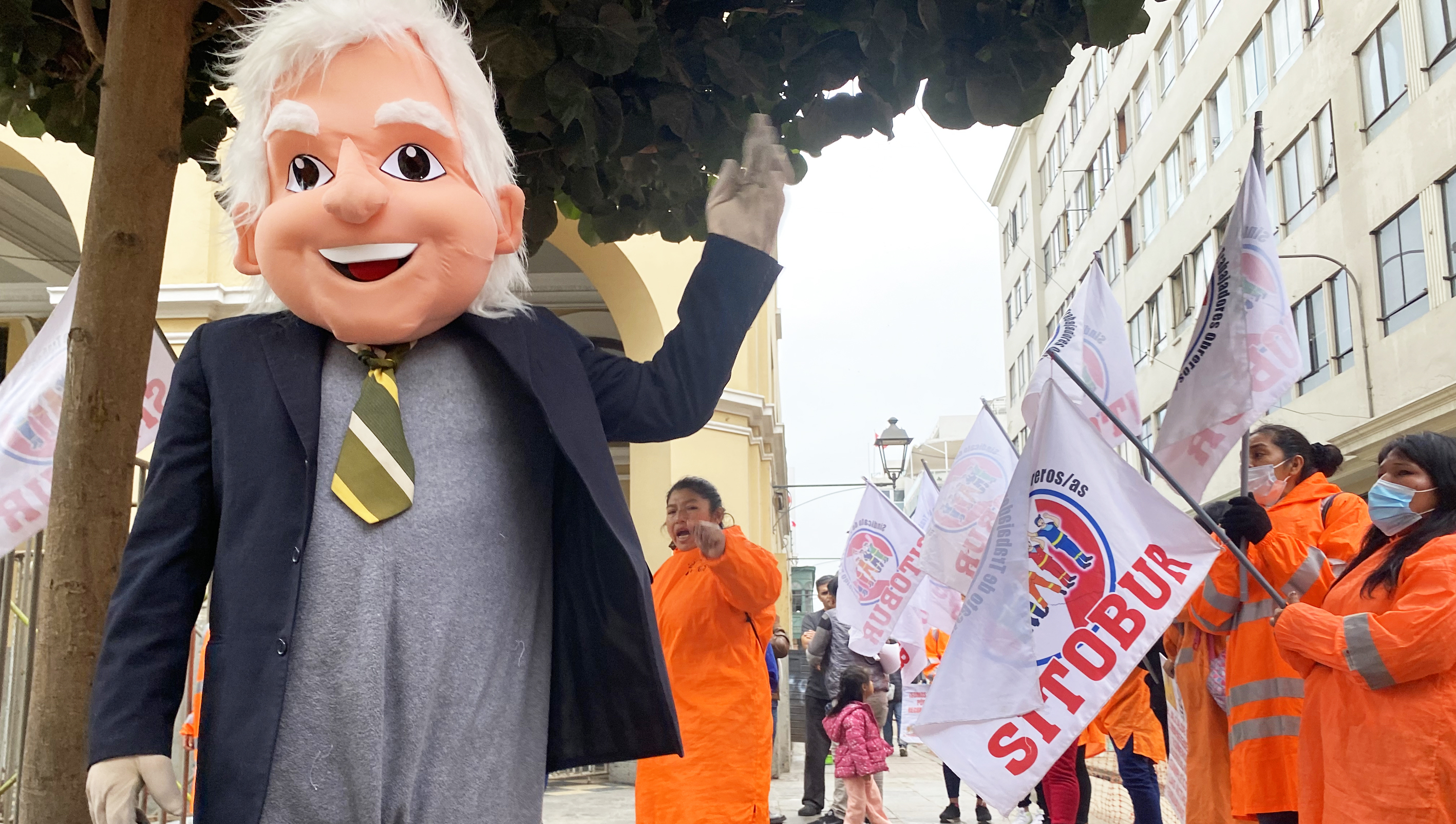 Kommunalarbetare i orange kläder demonstrerar i Lima.