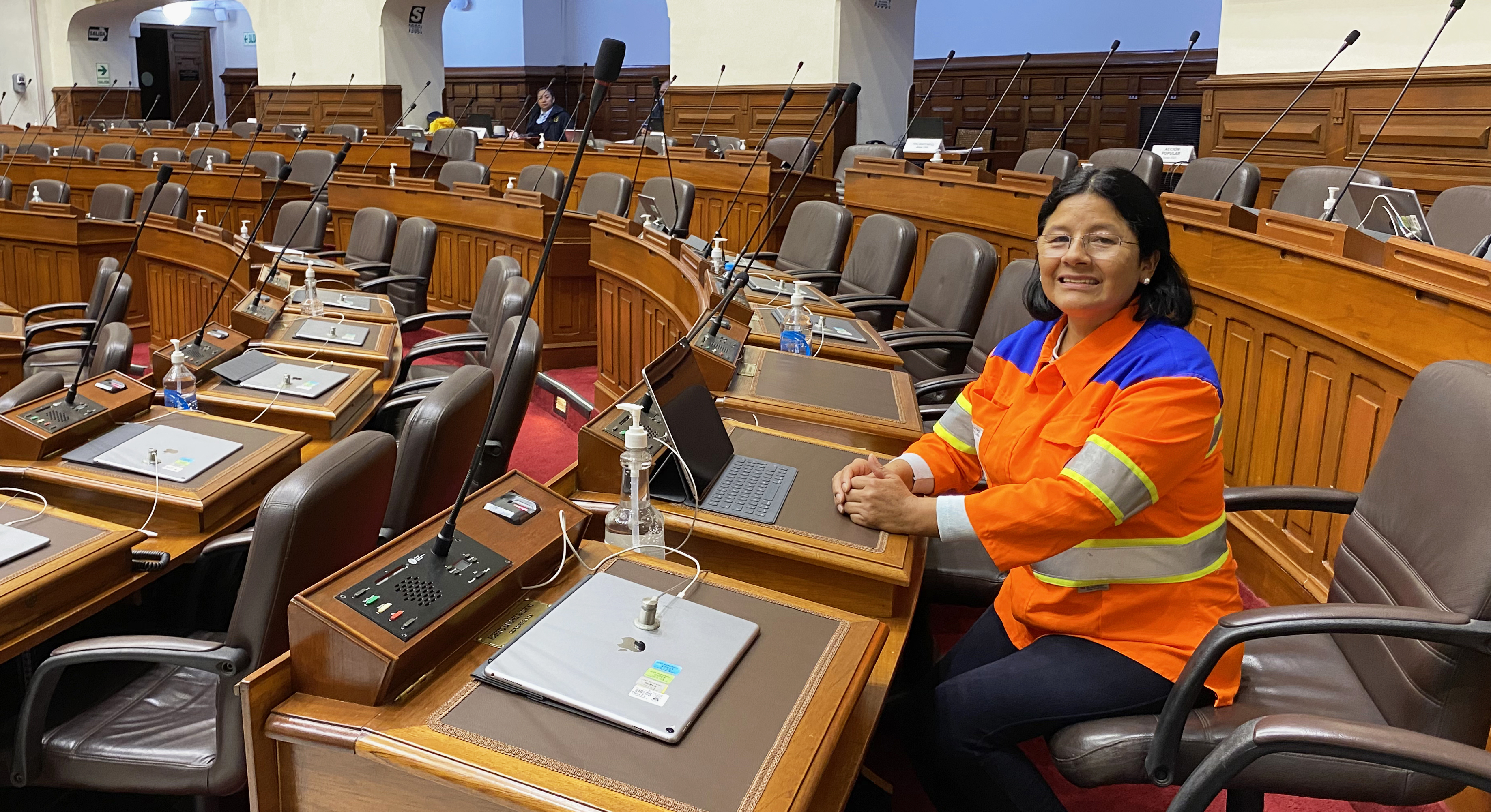 En kvinna i varselkläder sitter i Perus parlament.