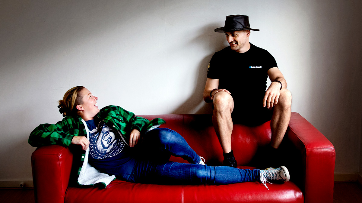 Emily Anfjord occh Sami Bes på en röd soffa.