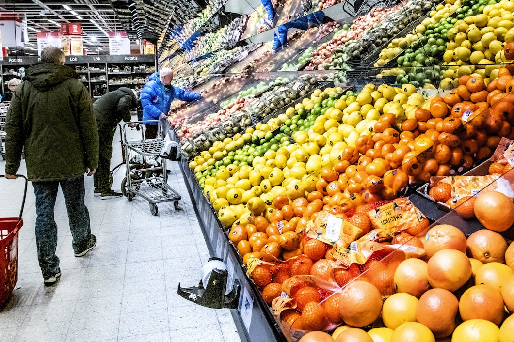 Personer handlar grönsaker i en matbutik.