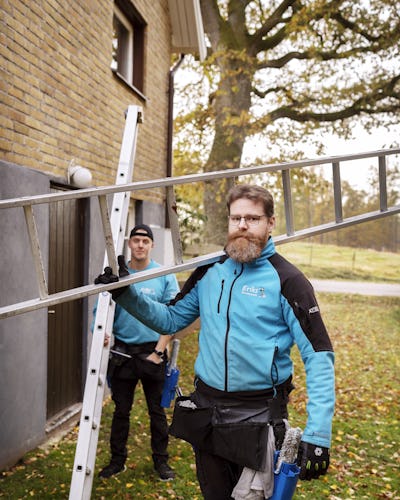 Viktor Sjöberg och Niclas Bildtgård vid en tegelhusvägg med stegarna.