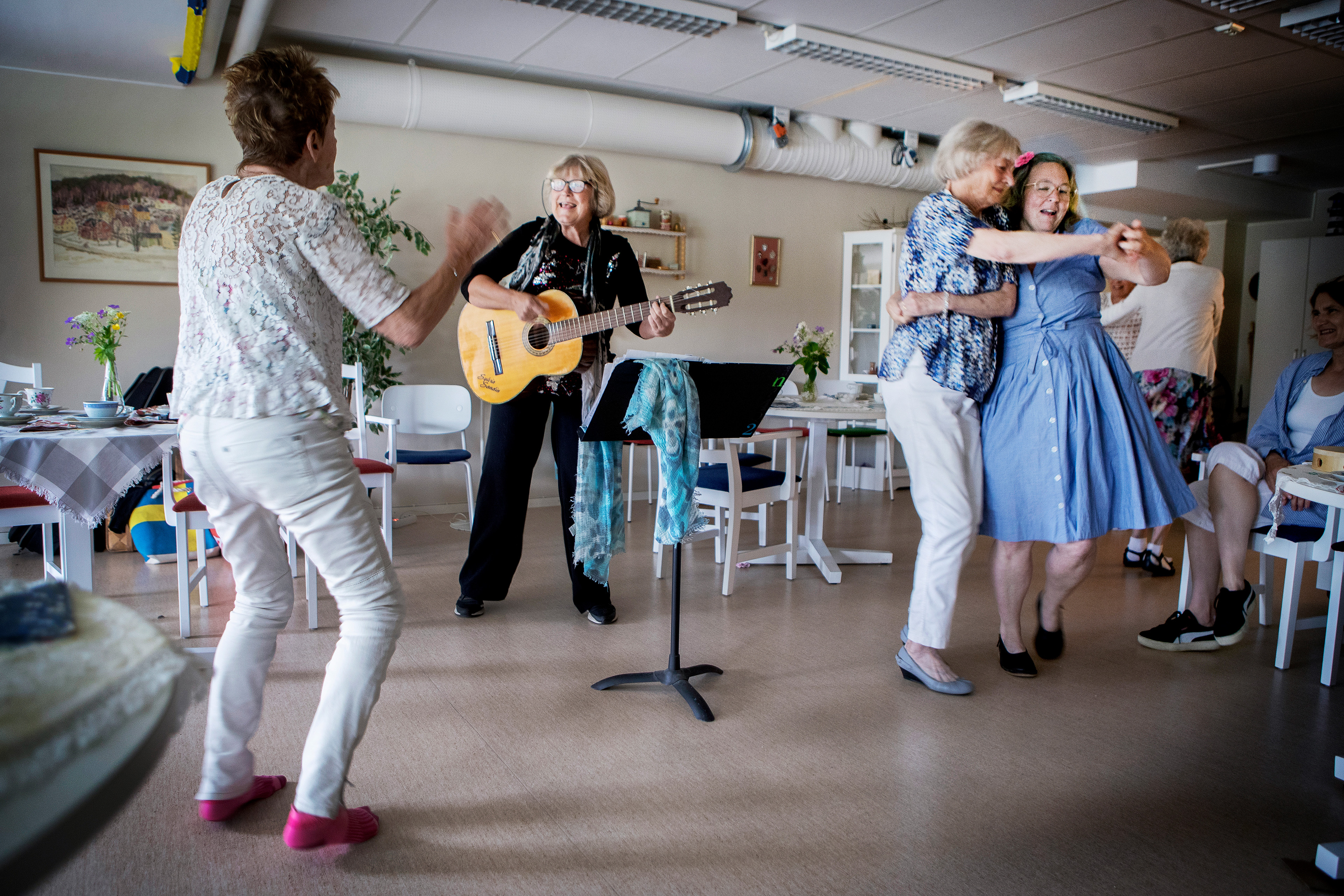 Sylvia Sandin spelar gitarr för äldre personer.