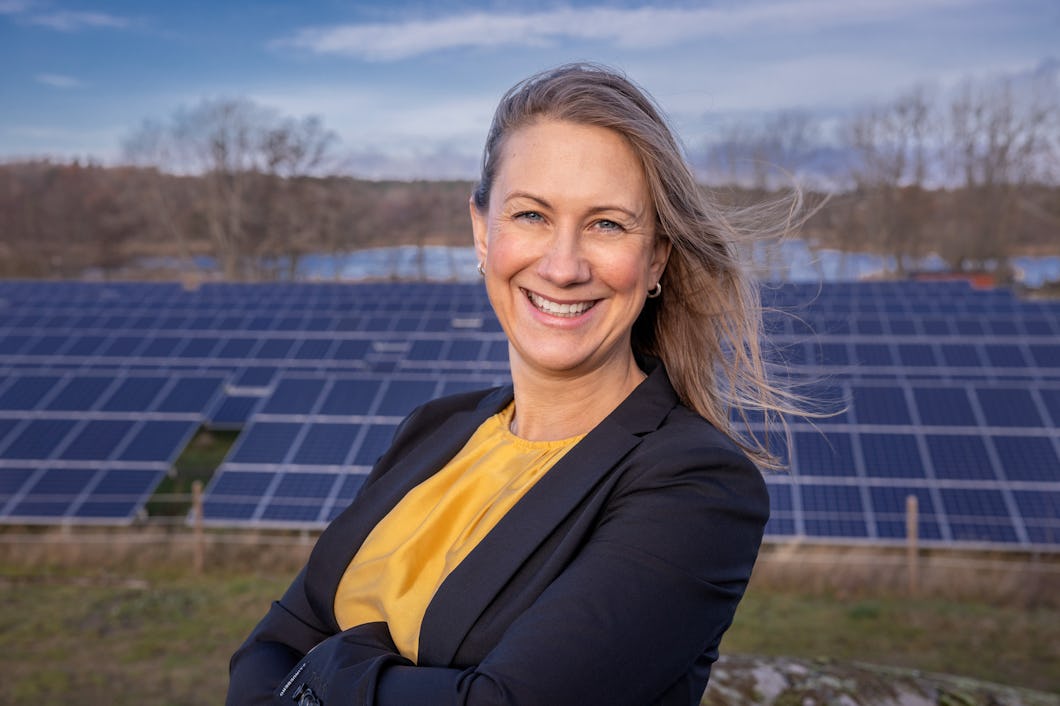 Bild i halvfigur på Anna Werner med solceller i bakgrunden.